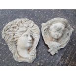 A wall mounted stone planter in the form of a cherub's face and a wall mounted plaque depicting a