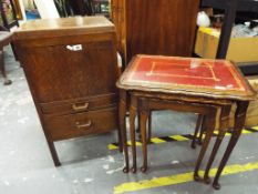 A nest of three tables glass topped and a sewing cupboard with contents.