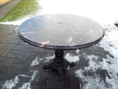 A faux marble top table on cast iron supports approx 72cm x 96cm (diam) Est £30 - £50