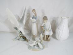 Three Lladro figurines to include 4550 'Turtle Dove', 4505 'Girl With Lamb' and a seated boy,