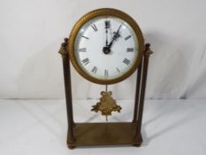 A brass cased portico styled mantel clock, white enamel dial with Roman numerals,