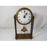 A brass cased portico styled mantel clock, white enamel dial with Roman numerals,