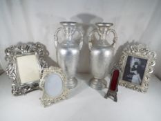 A pair of twin-handled urns and four highly decorative photograph frames,