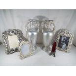 A pair of twin-handled urns and four highly decorative photograph frames,