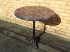 A faux marble top table on cast iron support approx 73cm x 68cm (diam) Est £20 - £30
