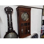 An oak cased wall clock having Arabic numerals to the silvered dial, with pendulum and key,