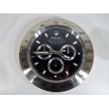 A decorative advertising wall clock in the style of a Rolex wristwatch,