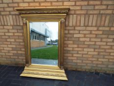 An ornate gilded French wall mirror with two supporting columns approx 140cm x 104cm Est £80 - £120