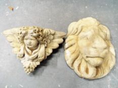 A stone wall mounted plaque depicting a cherub's face and a stone mask in the form of a lion (2)