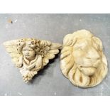 A stone wall mounted plaque depicting a cherub's face and a stone mask in the form of a lion (2)