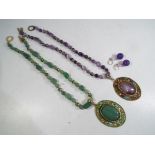 Two natural hardstone necklaces with enamelled pendants with large centre stone and one pair of