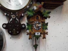 A wall mounted Cuckoo Clock, the case carved with oak leaves,