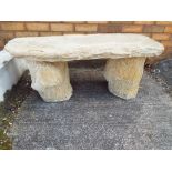 A large stone bench in the form of a tree trunk,