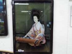 A Japanese reverse painting on glass picture depicting a Japanese lady playing a Koto,