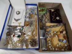 Two boxes containing a quantity of vintage costume jewellery, lighters, cufflinks, brooches,
