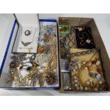 Two boxes containing a quantity of vintage costume jewellery, lighters, cufflinks, brooches,