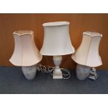 A pair of ceramic based table lamps decorated flowers and butterflies and a further table lamp with
