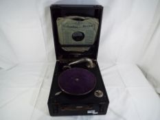 A Roesselbell wind-up gramophone with spare needles and two records, appears to be in working order.