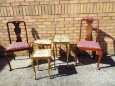 A gilded and decorative nest of three tables and a pair of mahogany Queen Anne style dining chairs.
