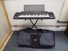 An electronic Yamaha PSR 100 on stand and a Tribal Planet carry case