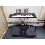 An electronic Yamaha PSR 100 on stand and a Tribal Planet carry case