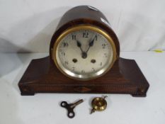 A good quality oak cased mantel clock with pendulum and key
