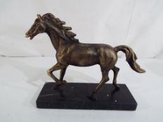 A figurine depicting a bronzed horse on a marble plinth,