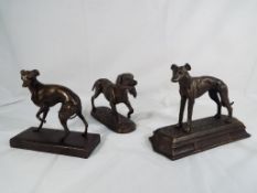 Three cast bronzed dogs on plinths.