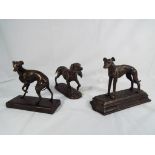 Three cast bronzed dogs on plinths.