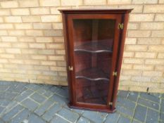 A mahogany wall mounted corner cabinet with glazed front opening and shelved interior 96 cm (h) x