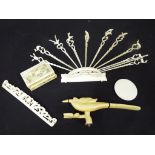 A collection of antique worked ivory to include a stand containing hat pins depicting various