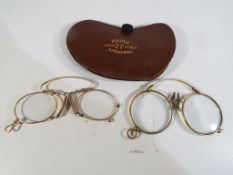 Two pairs of yellow metal framed pince nez reading spectacles and a leather case marked Haigh 77
