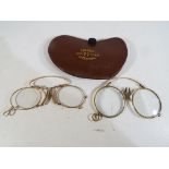 Two pairs of yellow metal framed pince nez reading spectacles and a leather case marked Haigh 77