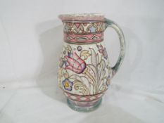 A Charlotte Rhead water jug decorated in a floral pattern, stamped with makers mark, T.L 76.A.
