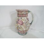 A Charlotte Rhead water jug decorated in a floral pattern, stamped with makers mark, T.L 76.A.