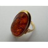 A lady's gold ring stamped 585 and set with a large amber stone, size L+, approx weight 5.