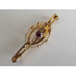 A 9 carat antique gold bar brooch set with garnet and seed pearls (a/f)