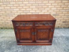 A reproduction two door, two drawer linen-fold, Priory style side cabinet,