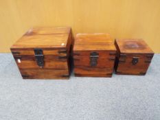 Three graduated wooden storage boxes with metal banding handles and locks,