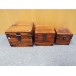 Three graduated wooden storage boxes with metal banding handles and locks,