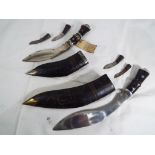 Two Indian made Kukri knives with companion knives in leather covered wooden sheathes Est £20 - £30