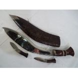 A chrome plated Kukri knife with two companion knives, in a leather covered wooden sheath.