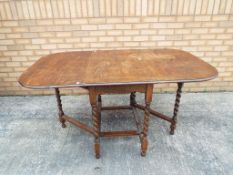 A good quality gate-leg table with barley twist legs, approximately 74.