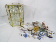 A glass display cabinet containing approximately 25 crystal figures,