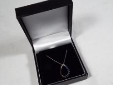 A lady's 9 carat white gold blue sapphire tear-drop pendant and chain, approx 1.
