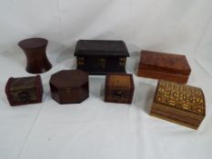 A wooden cigarette box and six wooden trinket boxes of varying size and styles