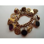A 9 carat gold charm bracelet with a selection of 9 carat gold fobs and a George V half-Sovereign,
