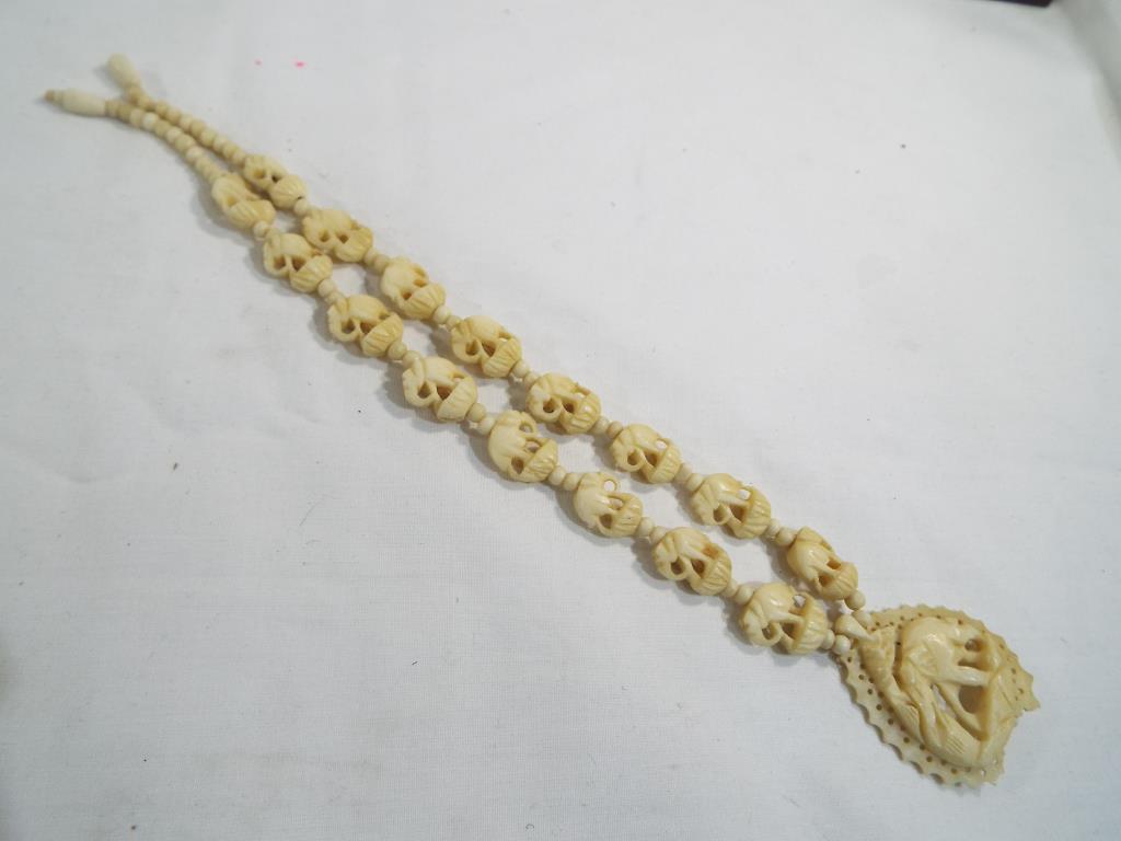 A carved bone necklace and pendent with screw clasp