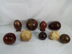 Nine decorative eggs and spheres comprising ceramic, wooden,