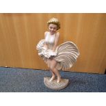 A large cast iron door stop depicing Marilyn Monroe,